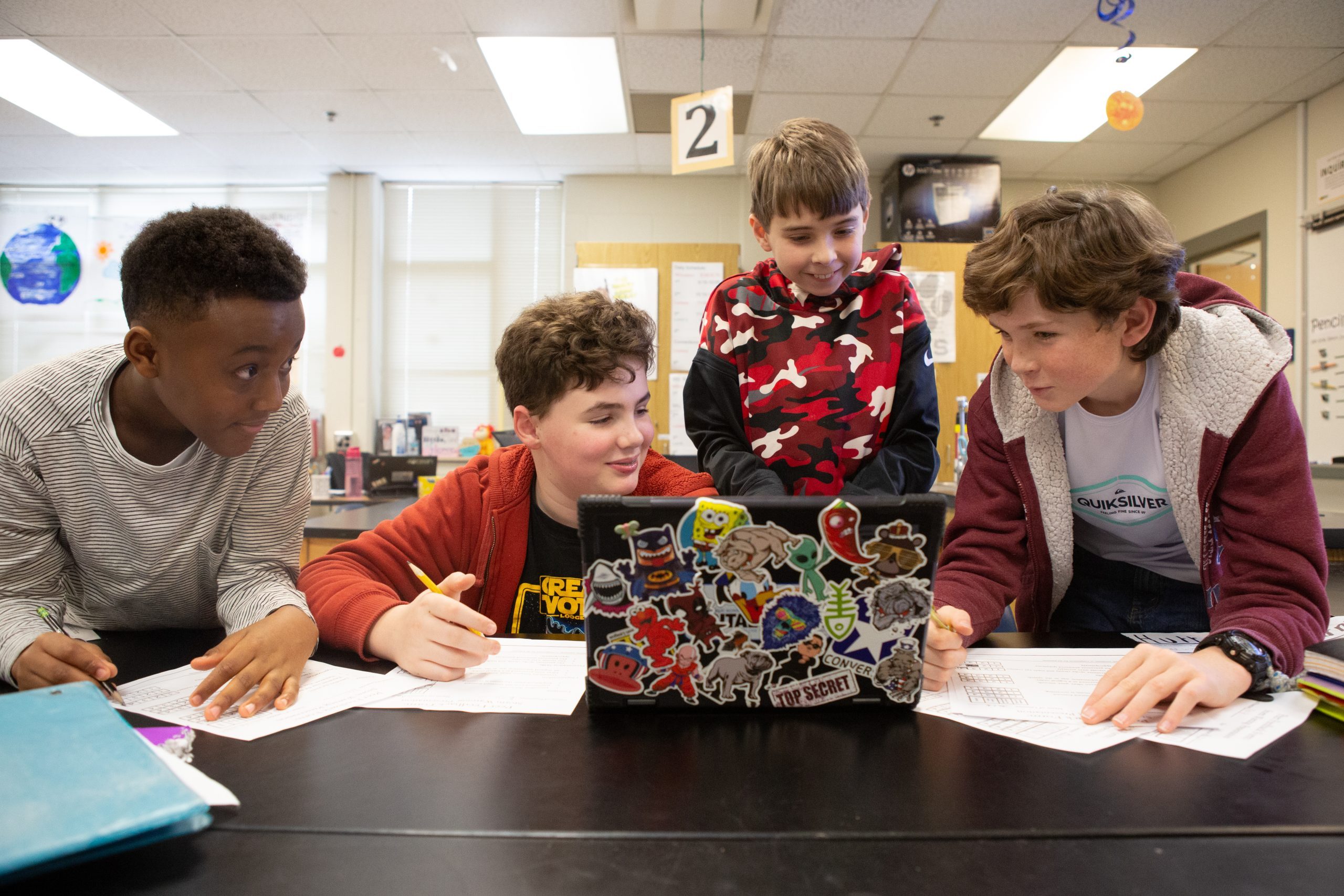 Four male middle school students working on a project